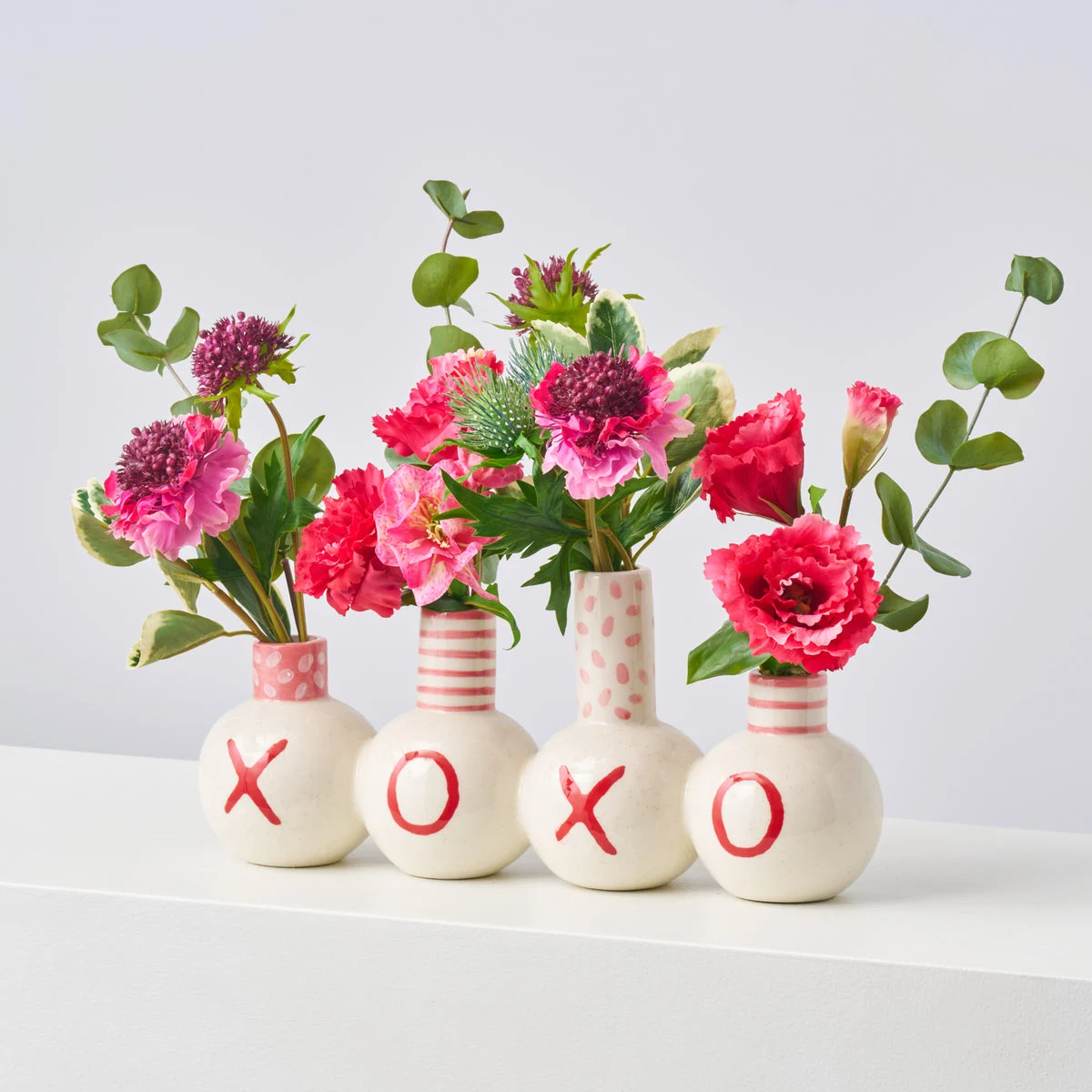 A Little XOXO - Fuchsia Lisianthus, Scabiosa & Helleborus with Mixed Greenery & Thistles in Love Note Budvase Spring Arrangement